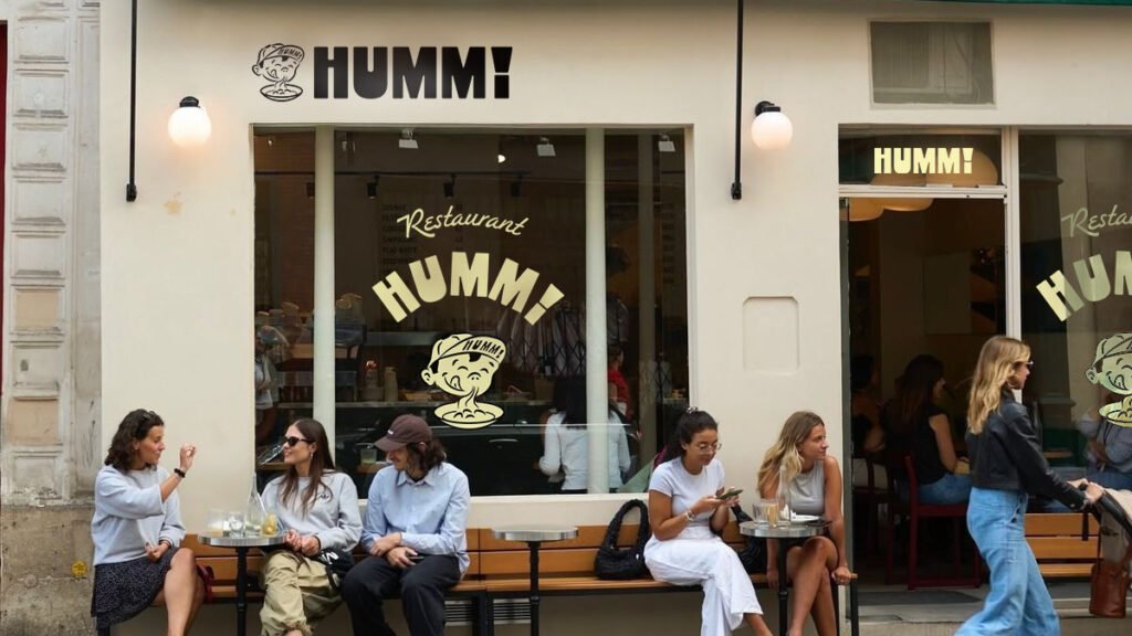 des gens branchés attablés devant la façade du restaurant humm!