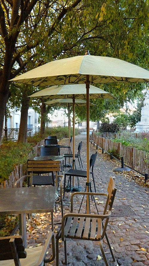 Chaises et parasols sur une terrasse de café de la ville de Montpellier, le matin